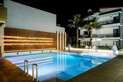 a swimming pool in front of a building at night at Cozy Spot near the beach in Plataniás