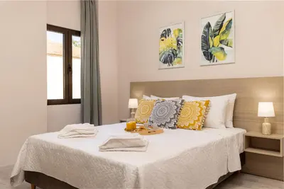 a bedroom with a large bed with yellow and gray pillows at Strat's City Loft in Chania Town