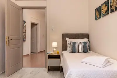 a bedroom with a bed and a table with a lamp at Strat's City Loft in Chania Town