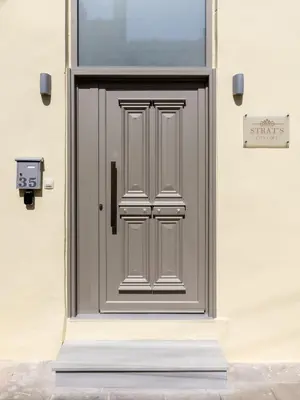 a grey door on a building with a sign on it at Strat's City Loft in Chania Town