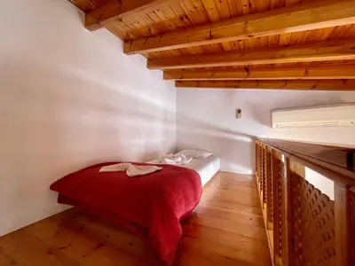 a small room with a bed with a red blanket at Odyssey House in Chania Town