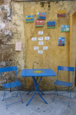 a blue table and two chairs in front of a wall at Odyssey House in Chania Town