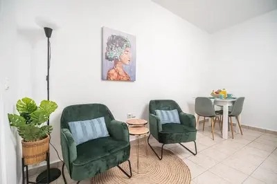 a living room with two green chairs and a table at ''Meraviglia casa'' Christin in Kato Daratso