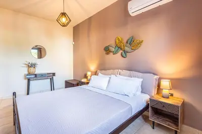 a bedroom with a bed with white sheets and two lamps at Celeste Suite on the Beach in Agia Marina Nea Kydonias