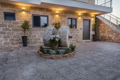 a stone fountain in front of a building at Celeste Suite on the Beach in Agia Marina Nea Kydonias