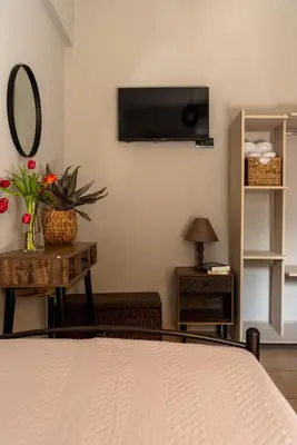 a bedroom with a bed and a tv on the wall at Celeste Suite on the Beach in Agia Marina Nea Kydonias