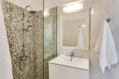 a bathroom with a sink and a shower with a mirror at Villa Aggeliki by Villa Plus in Pírgos Psilonérou