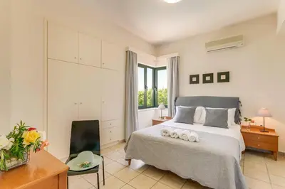 a bedroom with a bed with two pillows on it at Villa Anni by Villa Plus in Pírgos Psilonérou