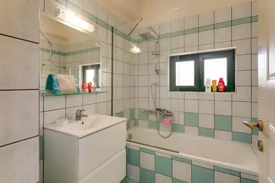 a bathroom with a sink and a shower and a tub at Villa Anni by Villa Plus in Pírgos Psilonérou