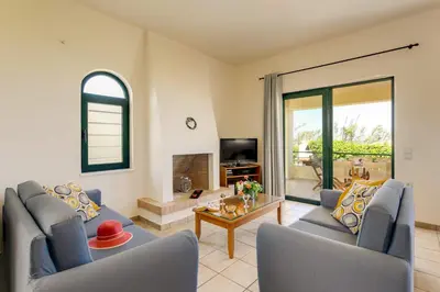 a living room with two blue chairs and a table at Villa Anni by Villa Plus in Pírgos Psilonérou