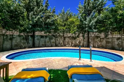 a swimming pool with chairs and a fence at Villa Areti by Villa Plus in Spiliá