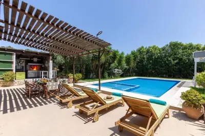 a patio with chairs and a swimming pool at Villa Liostasi by Villa Plus in Agia Marina Nea Kydonias