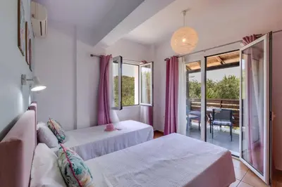 a bedroom with two beds and a balcony at Villa Liostasi by Villa Plus in Agia Marina Nea Kydonias
