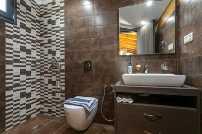 a bathroom with a toilet and a sink and a mirror at Villa Potami Angela by Villa Plus in Stílos