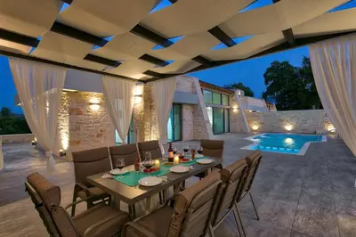 an outdoor dining room with a table and chairs at Villa Potami Nikos by Villa Plus in Stílos