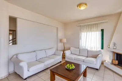 a living room with two white couches and a coffee table at Villa Katerina Pente by Villa Plus in Kalyves