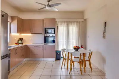 a kitchen with a table and chairs and a ceiling fan at Villa Katerina Pente by Villa Plus in Kalyves