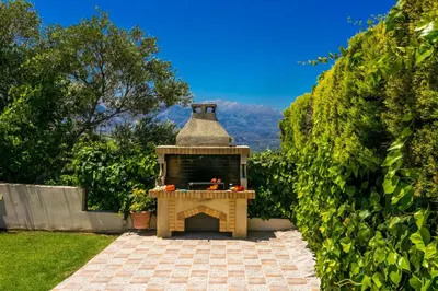 a outdoor pizza oven in a yard with trees at Villa Margarita Exi by Villa Plus in Kalyves