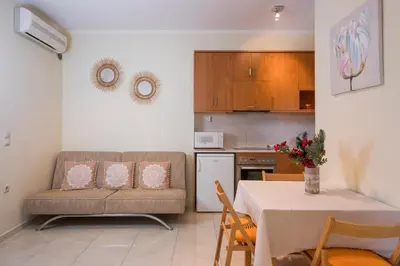 a kitchen and a living room with a couch and a table at Luxury Coastal Retreat, Mountain View Balcony with Palm Trees & Parking in Chania Town