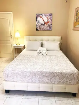 a bedroom with a large white bed with two towels on it at Christina_Apt in Chania Town