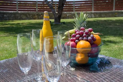 a table with a bowl of fruit and a bottle of champagne at Villa Ciel in Agios Padeleimon