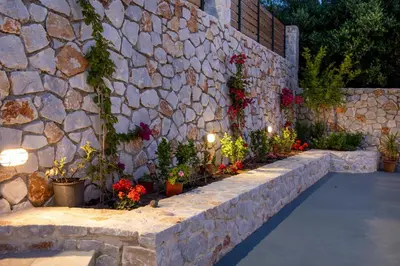 a stone wall with potted plants and flowers on it at Villa Denise in Kalyves