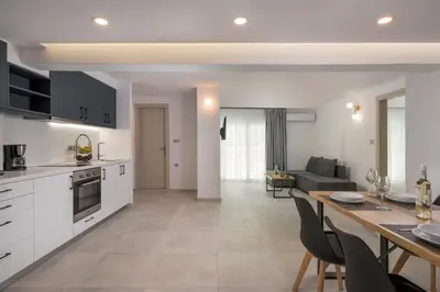 a kitchen and living room with a table and chairs at Quarters Luxury Apts in Chania Town
