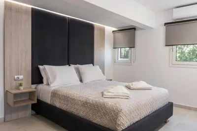a bedroom with a large bed with a black headboard at Quarters Luxury Apts in Chania Town