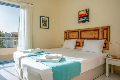 a bedroom with two beds with towels on them at Aris Apartment in Palaiochóra