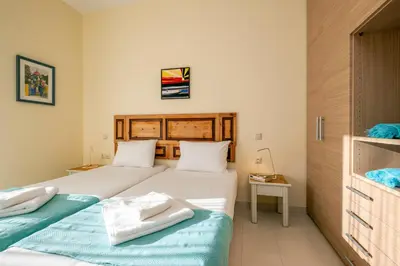 a bedroom with two beds with towels on them at Aris Apartment in Palaiochóra