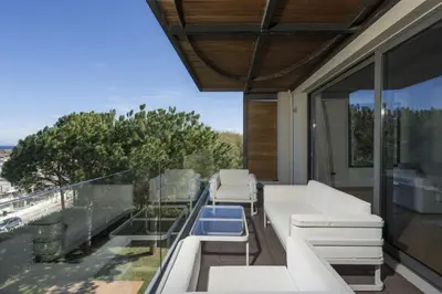 a balcony with white furniture and glass walls at Luxury Villas near The Sea With Heated Pool in Kato Daratso