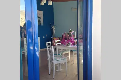 a dining room with a table with flowers on it at Great sea-view apartment. in Khóra Sfakíon