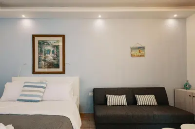 a bedroom with a bed and a chair at Villa Paparouna in Chania Town