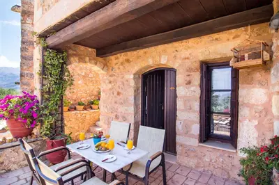 a table and chairs on the patio of a house at Samonas - Blue villa Mantzourana in Khiliomoudhoú