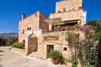 a building with flowers on the side of it at Samonas - Blue villa Mantzourana in Khiliomoudhoú