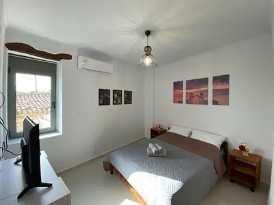 a bedroom with a bed and a desk and a television at DESTAN & JULIETTE SEA VIEW Villa in Kamisianá