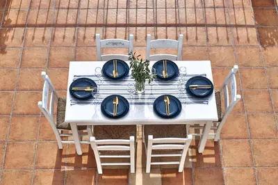a white table with chairs and blue plates on it at Villa Elia by PosarelliVillas in Vryses