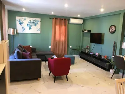 a living room with a couch and a tv at Πολυτελές οροφοδιαμέρισμα για ονειρικές διακοπές! in Chania Town