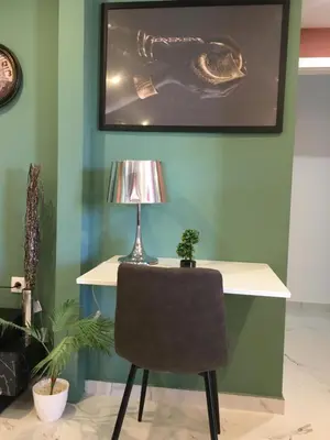 a desk with a lamp and a chair in a room at Πολυτελές οροφοδιαμέρισμα για ονειρικές διακοπές! in Chania Town