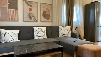 a living room with a gray couch with pillows at Άνετο και πολυτελές οροφοδιαμέρισμα 2 in Chania Town