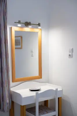 a white dressing table with a mirror on a wall at Jasmine Home by the Sea by 8essentially in Kalyves