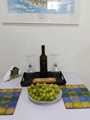 a table with a plate of grapes and a bottle of wine at Jasmine Home by the Sea by 8essentially in Kalyves