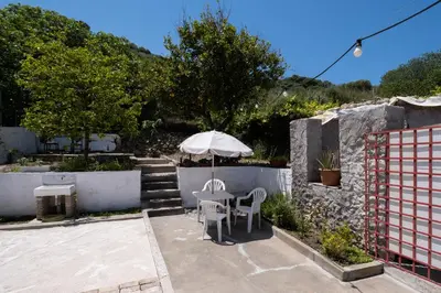 a patio with an umbrella and a table and chairs at Jasmine Home by the Sea by 8essentially in Kalyves