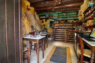 a wine tasting room with tables and racks of wine bottles at Samonas - Orange villa Diktamos in Khiliomoudhoú