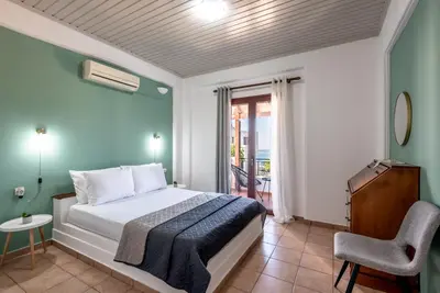 a bedroom with a bed and a chair and a window at ApteraMare Tradidtional house 'New listing' in Chania Town