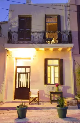 a white house with a balcony and a chair in front of it at Auntie's home by Chania Old Harbor in Chania Town