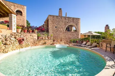 a large swimming pool in the middle of a yard at Samonas - Green villa Faskomilia in Chania Town