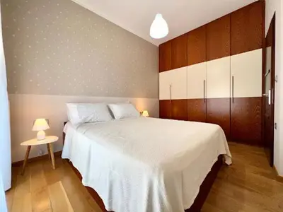 a bedroom with a large white bed and a table at Central apartment in quiet neighborhood near sandy beach in Chania Town