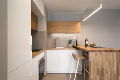 a kitchen with white cabinets and a counter with a sink at Noemie Luxury Suites in Chania Town