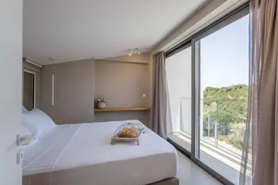 a bedroom with a bed and a large window at Noemie Luxury Suites in Chania Town